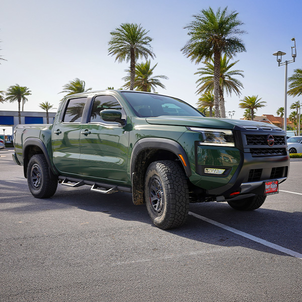 Side view of a Nissan Truck parked in the lot