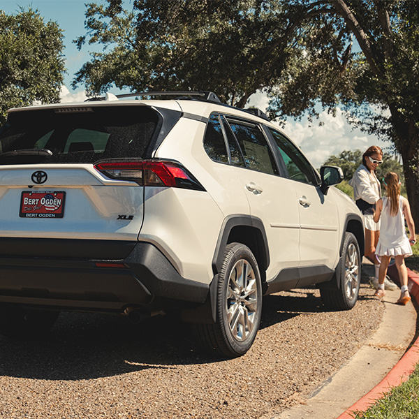 Bert Ogden Motors license plate on Toyota with family in front of vehicle