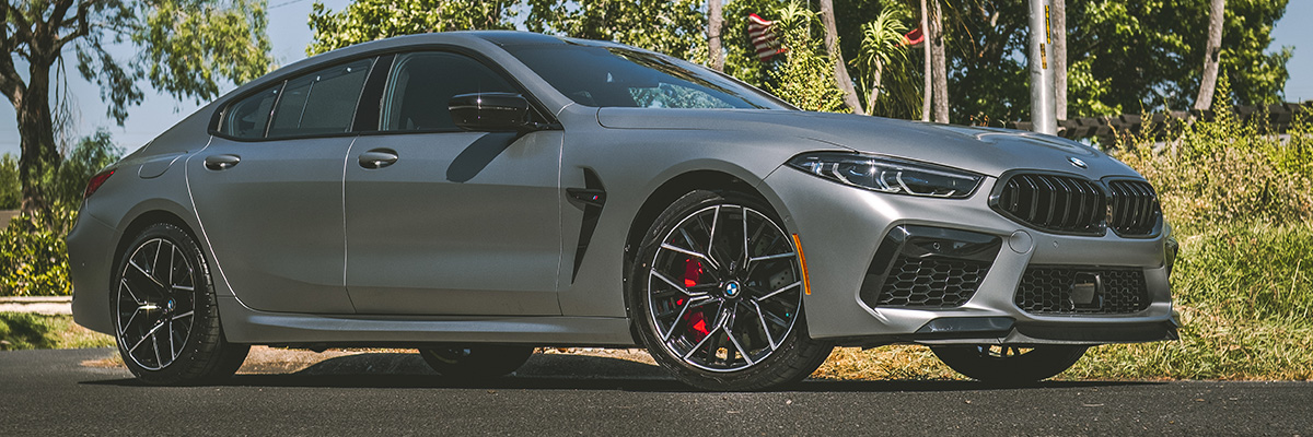 BMW sedan parked on a road next to a grassy area