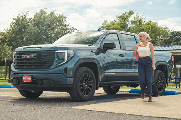Woman standing next to GMC truck