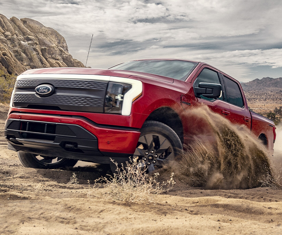 A 2023 Ford F-150 Lightning® being driven on a forested trail