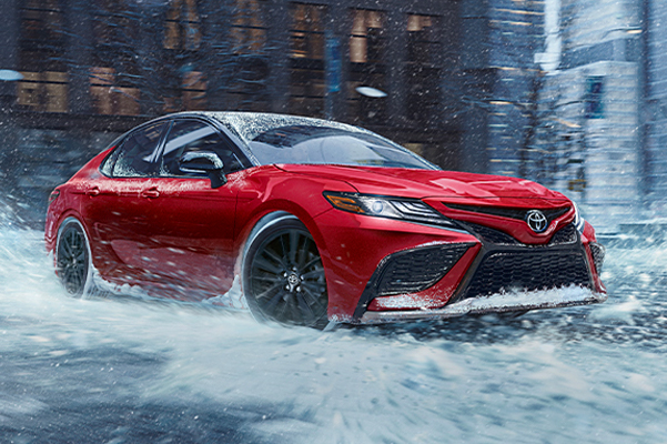 Camry XSE AWD in Supersonic Red w/ Black Roof, snow, city, buildings