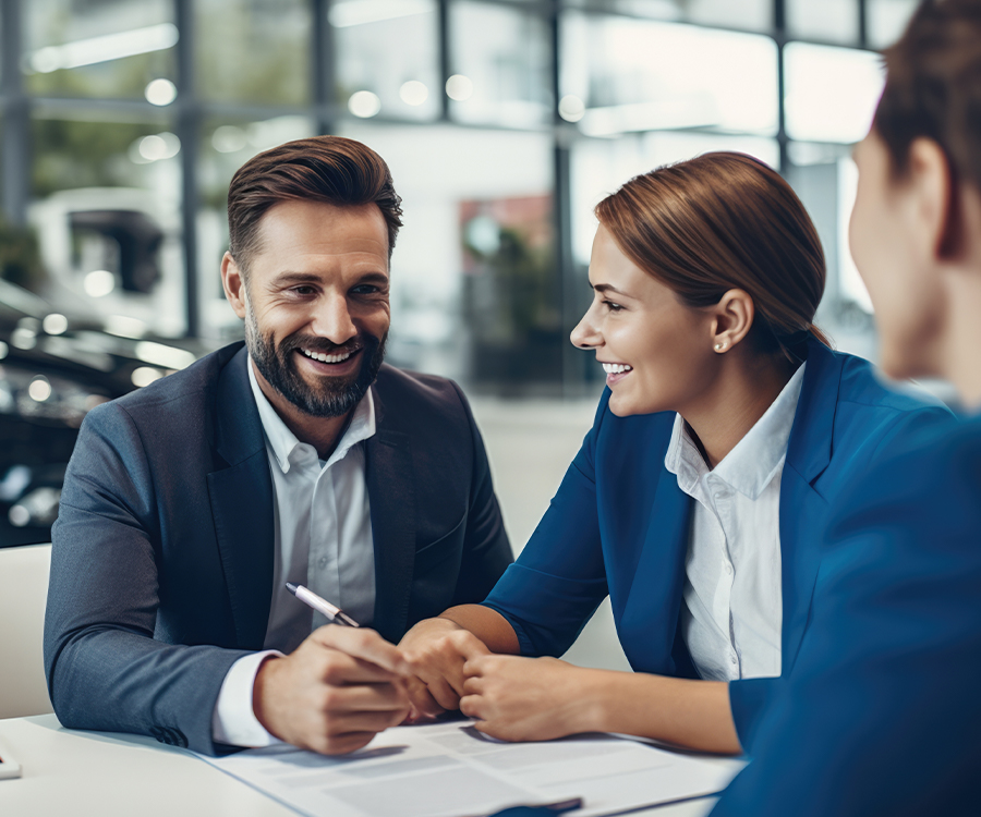 A couple buys a new car by signing a purchase agreement at a car dealership
