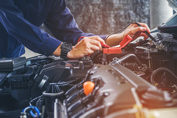 Mechanic in uniform is working in auto service. Car repair and maintenance.