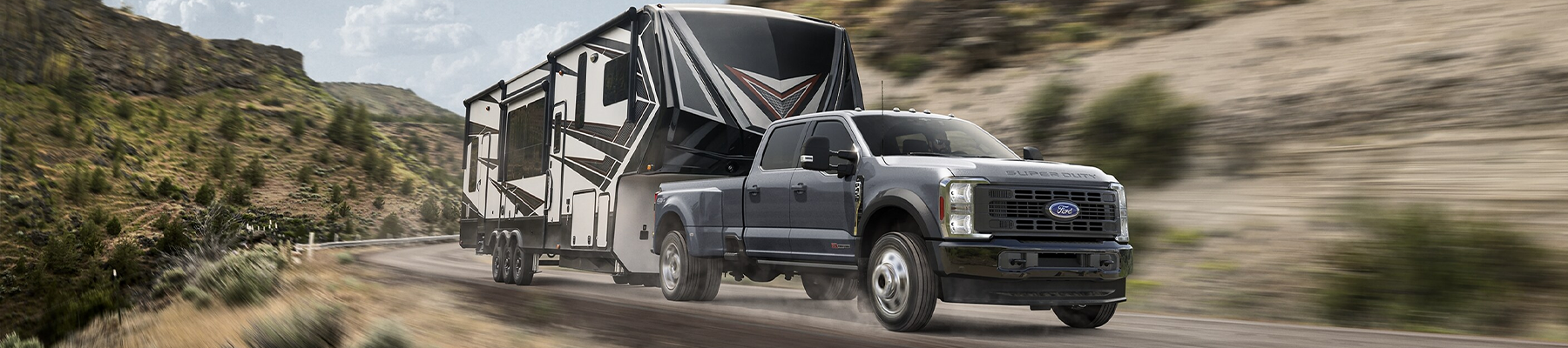 2024 Ford Super Duty® F-450® Limited model pulling a camper trailer on a mountain roadway