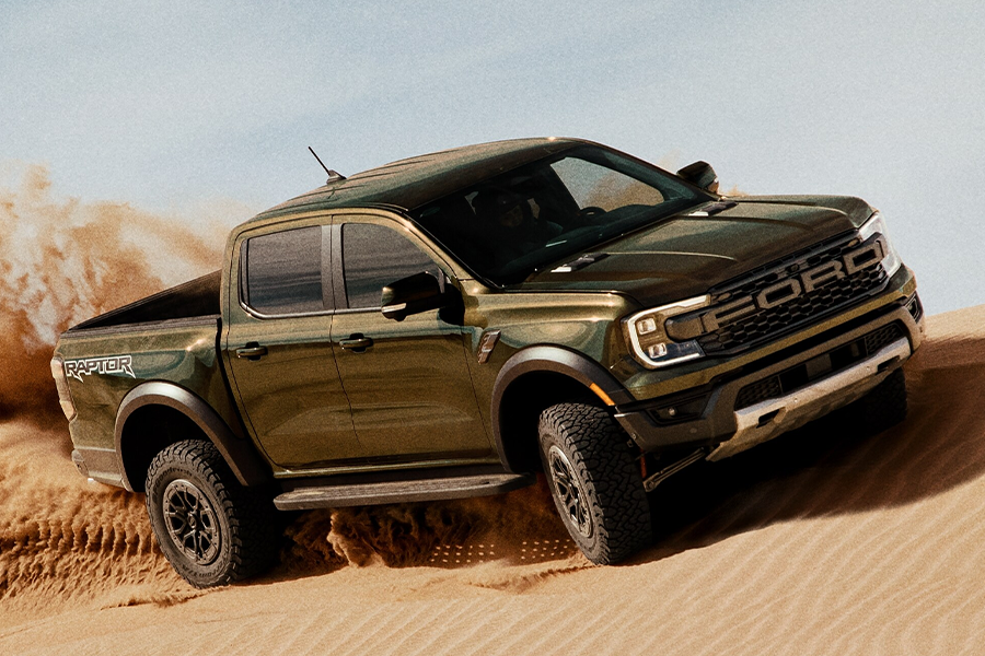 A 2024 Ford Ranger® Raptor® in Shelter Green is being driven on sand dunes