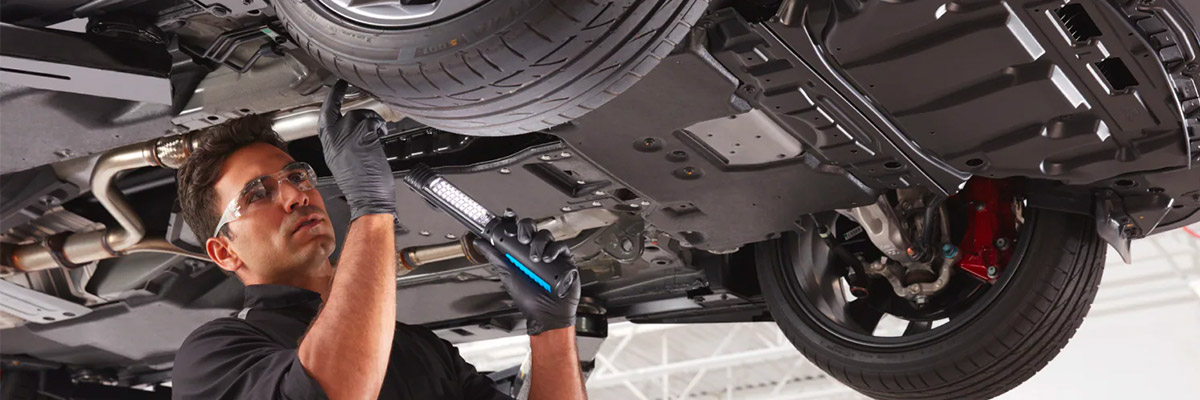 INFINITI technician working underneath car