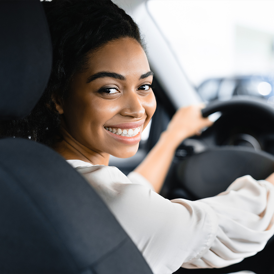 Woman Buying New Car Doing Test Drive In Dealership Store