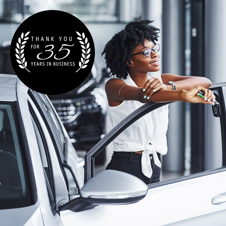 person smiling and resting on drivers side door with 35 Years logo