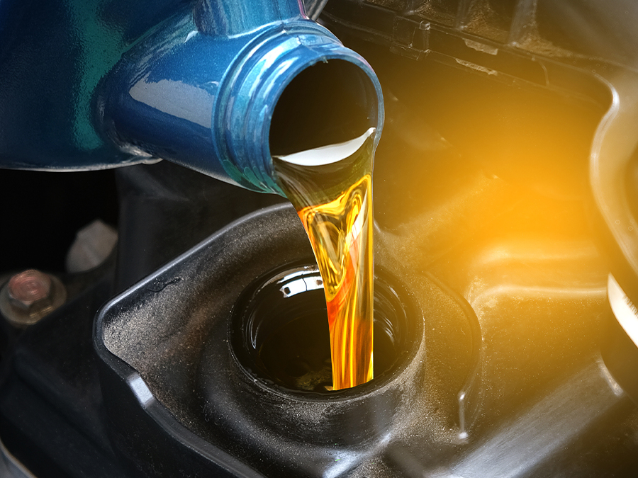 Service tech pouring oil into a vehicle for an oil change