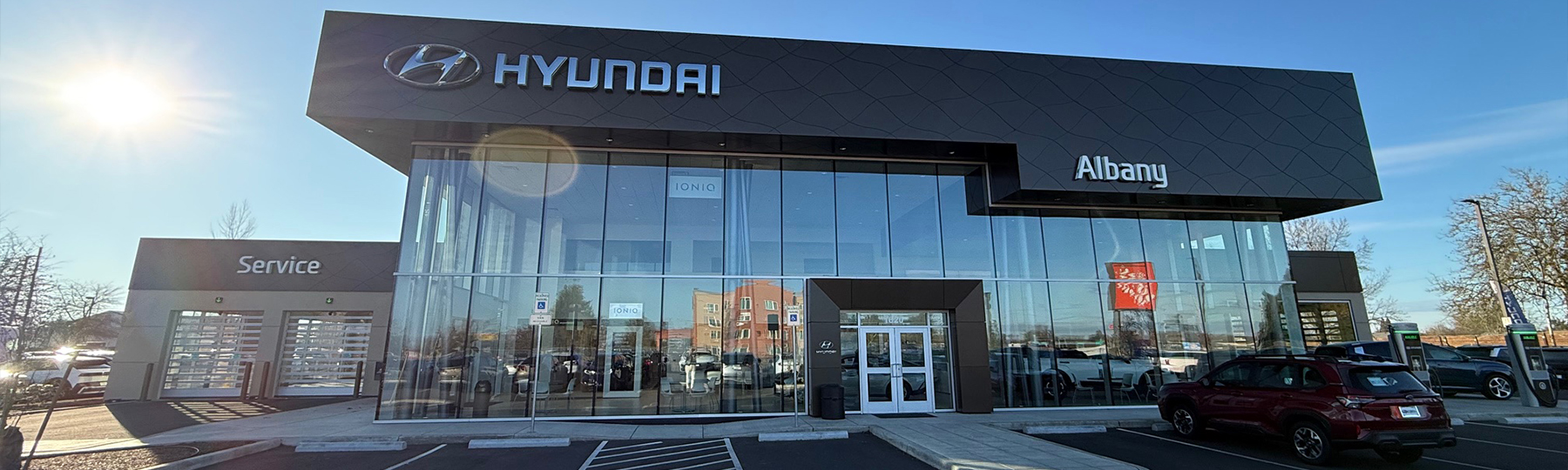 Dealership employee showing customers cars on showroom floor.