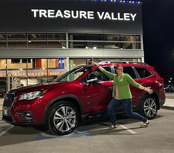 people standing outside the dealership with their new car