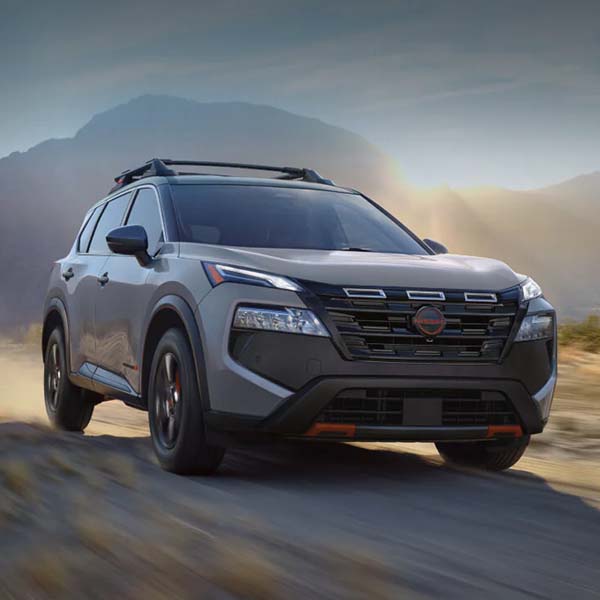 Nissan Rogue Rock Creek Edition driving on dusty road at dawn