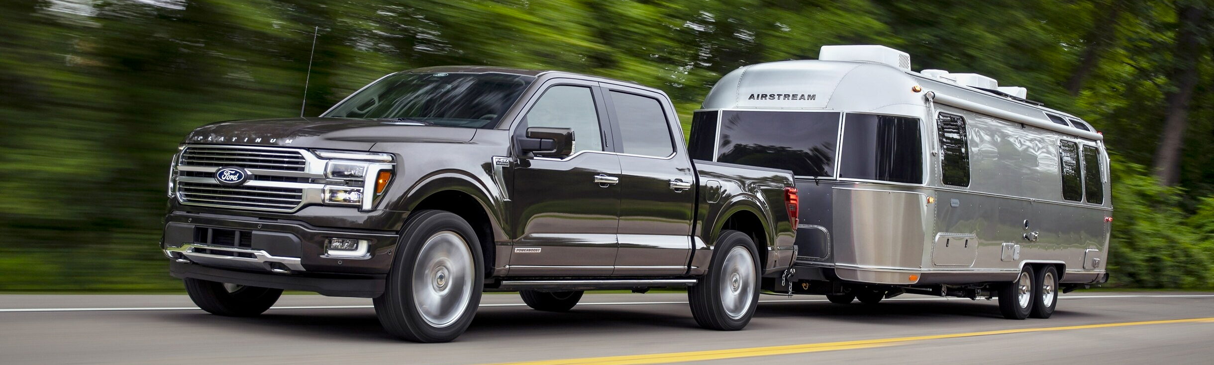 A 2024 Ford F-150® pickup in Agate Black pulling an Airstream Camper